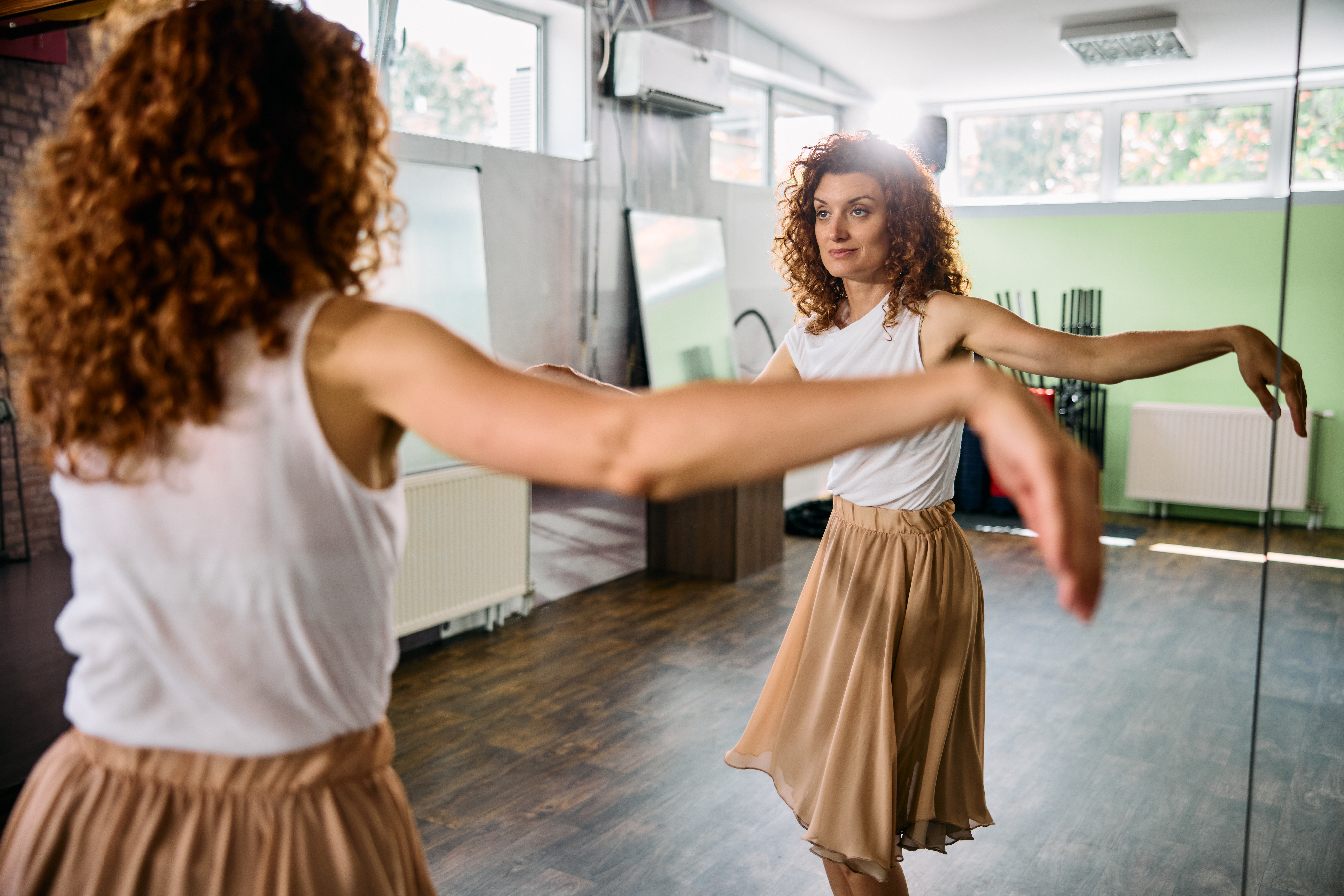 Partner dance reflecting communication and connection through movement in front of a mirror